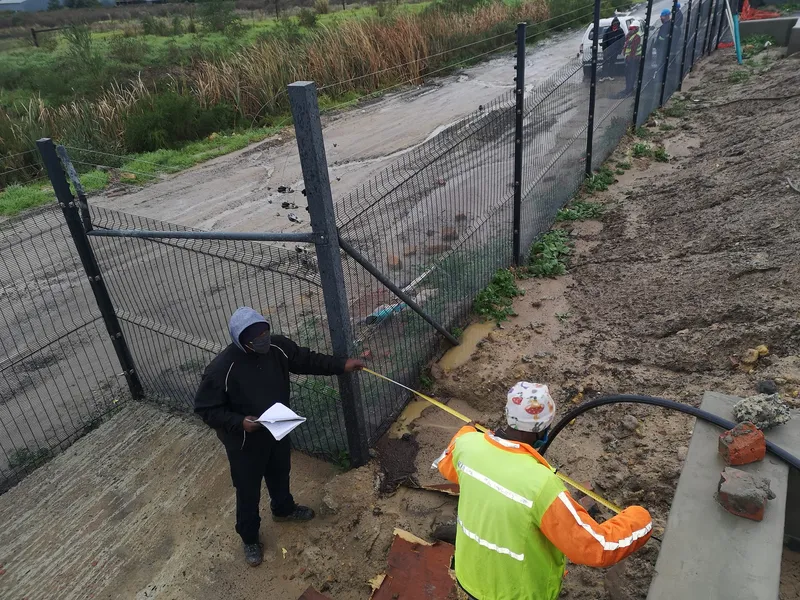 Workers measuring and installing clearview at development site