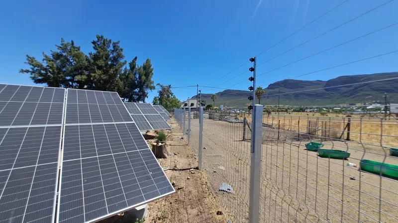 Electric fence with solar power panels and mountain views