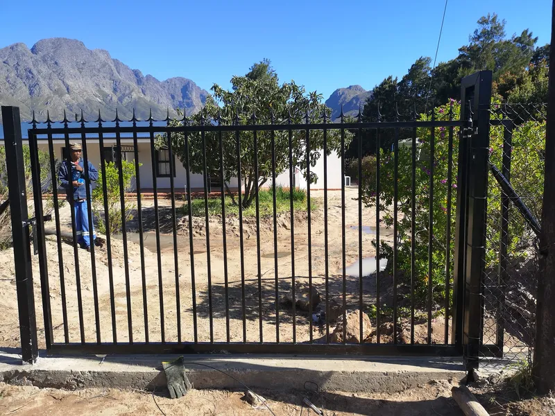 Black palisade driveway gate with Franschhoek mountain views